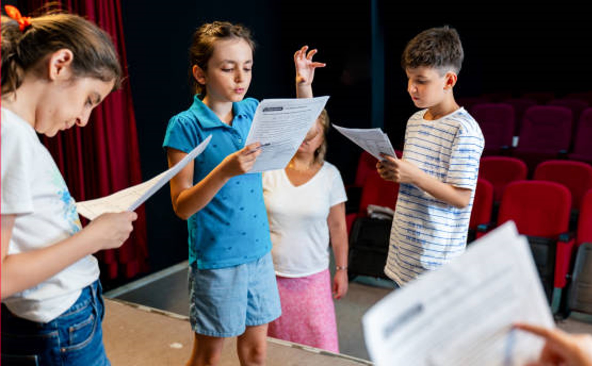 Kinder proben mit Texten auf einer Bühne für die Schauspielkurse